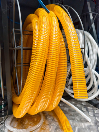 Yellow corrugated hose coiled neatly is displayed on hardware store shelves among construction and utility supply products