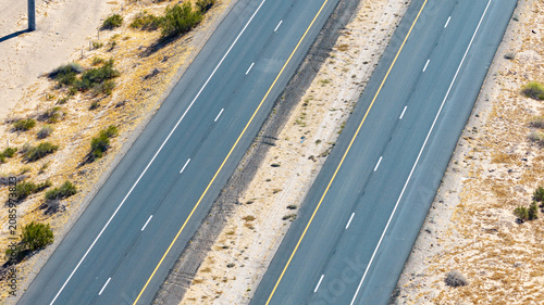Obraz na plátne Aerial Close-Up of Empty Multi-Lane Desert Interstate Highway with Yellow and Wh