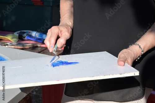 Fotografía artista spalma i colori a tempera su di una tavolozza bianca