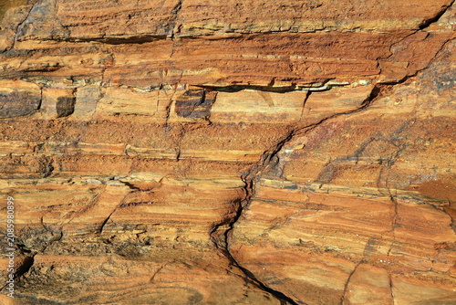 Faszinierende Sandsteinformation mit markanten Sedimentschichten und bunten Kieselsteinen. Hochwertige Detailaufnahme von geologischer Struktur und Erosion für Stockfotografie.