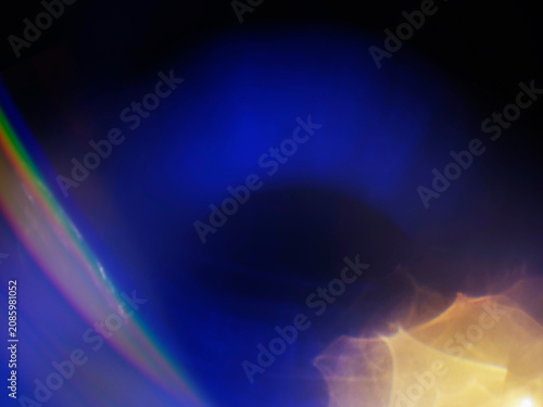 Warm orange and blue light leaks on black. Abstract background for design and special effects. Random shapes and form. Lens flare.