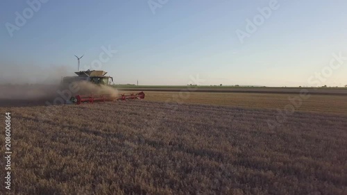 Cinematic Drone Orbit Shot of Combine Harvester Working in Harvested Field