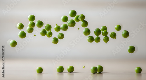 Frozen motion of fresh green peas falling and scattering on a light surface