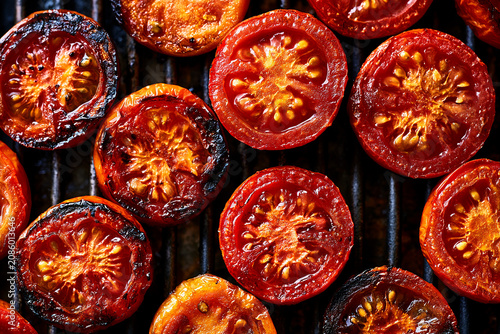 Close Up Overhead View of Grilled Red Tomato Halves on a Barbecue Grate.