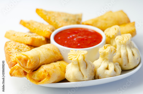 Plated snack platter features appetizing rolls and dumplings