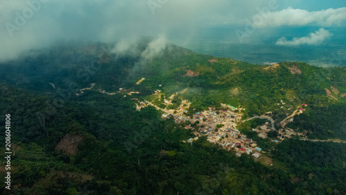 Aerial view of Mt. Gemi and the village of Amedzofe nestled among lush green mountains with clouds and winding roads in Amedzofe, Volta Region, Ghana.