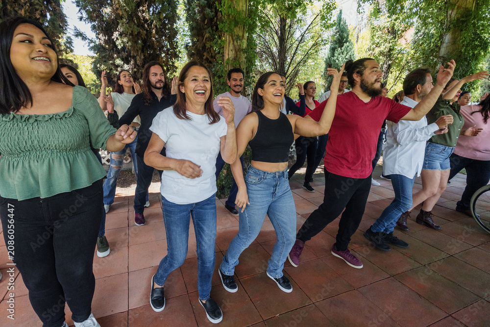 Fototapeta premium Group of latino friends enjoying a salsa dancing class outdoors in Mexico Latin America. Hispanic people moving to the rhythm and having a fun together