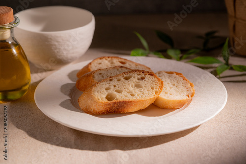 Rustic Sliced Artisan Bread with Olive Oil on White Plate, Cozy Food Photography
