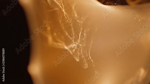 Golden smoke trail flowing against a dark background