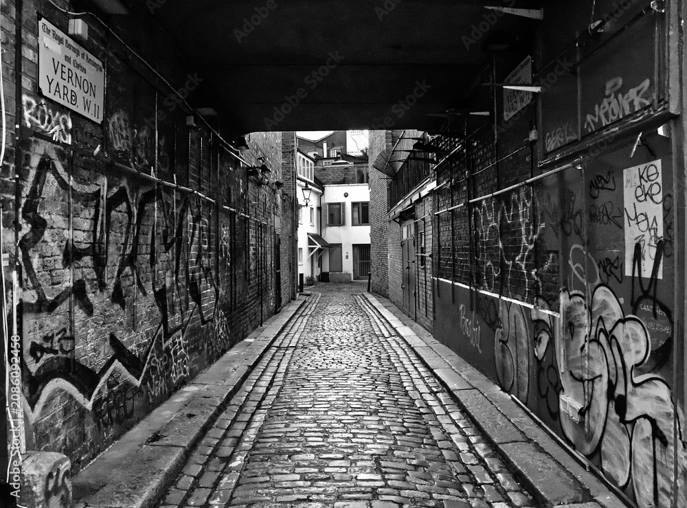 Fototapeta premium Black and white view of an urban pedestrian underpass with walls covered in graffiti, London