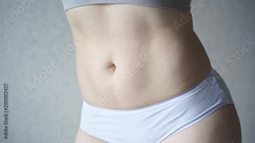 Static Shot Of Woman Torso Showing Subtle Breathing And Body Changes In White Underwear Against Neutral Studio Background.