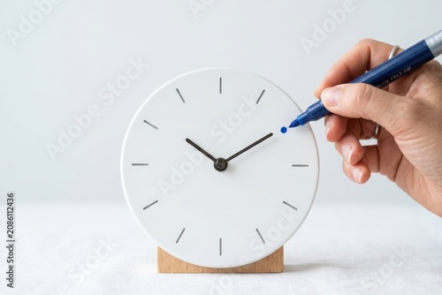 Minimalist Time Management Concept with Person Marking Appointment on White Clock Hero Header Design Space. Focus on productivity, deadline scheduling, and mindfulness in a clean modern office.