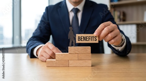 Professional businessman in a suit placing a wooden block labeled benefits on a staircase model
