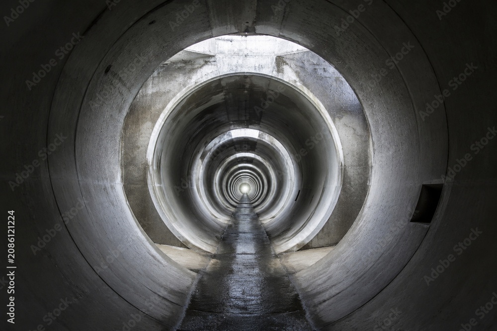 Fototapeta premium canalization. Interior of massive concrete drainage pipes in urban underground, leading to light. real-estate listings.