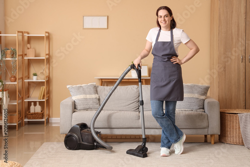 Young woman vacuuming livin...