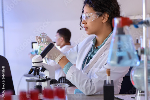 Female African-American chemist working at table in laboratory