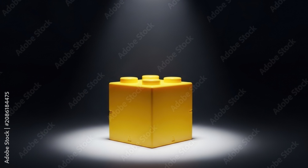 Obraz premium Yellow Lego Brick Under Spotlight Alone.