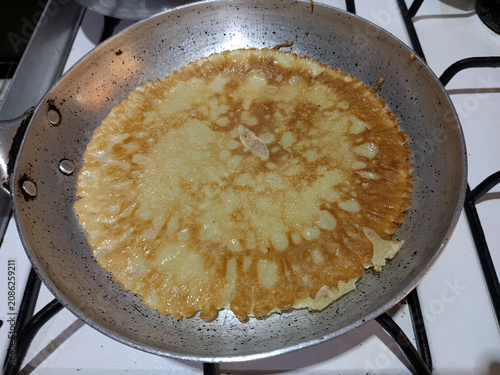 Konstfotografi Cooking pancake in frying pan on gas stovetop at kitchen