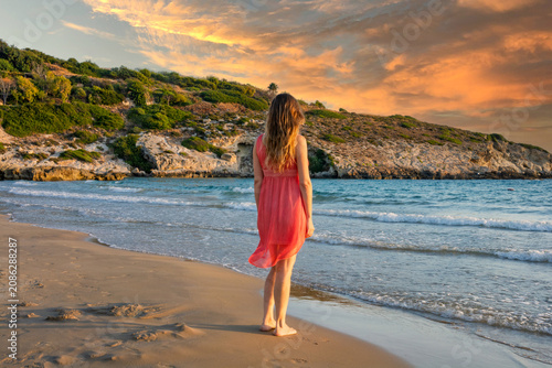 Symphony of crimson and gold where her dress lights up the sunset on the sea