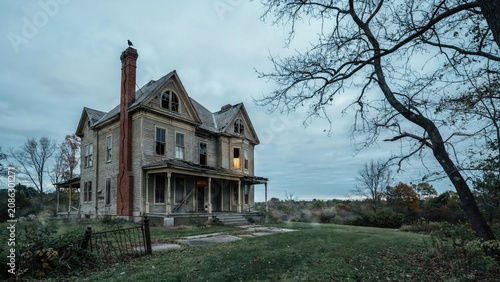 Abandoned victorian mansion with broken windows and overgrown yard