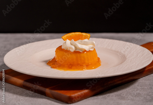 Orange Jelly Dessert with Whipped Cream and Fresh Orange Slice on White Plate,perfect for bakery, café, restaurant, and sweet treat concepts.