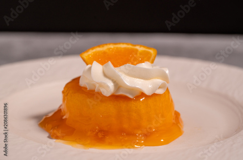 Orange Jelly Dessert with Whipped Cream and Fresh Orange Slice on White Plate,perfect for bakery, café, restaurant, and sweet treat concepts.
