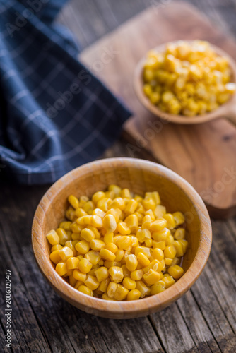 Obraz na plátne Fresh Sweet Corn Kernels in Wooden Bowl on Rustic Table With Blue Napkin Backgro