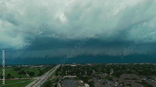Dark storm clouds forming over the countryside before severe weather. Dramatic shelf cloud approaching across open fields with an ominous sky, Wide aerial view