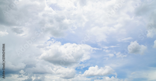 the sky is clear blue with fluffy white clouds, the sky is very bright, and the sun shines.