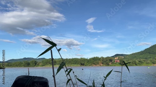 Traditional Bamboo Boat on the Mekong River with Mountain Landscape and Blue Sky in Northern Thailand