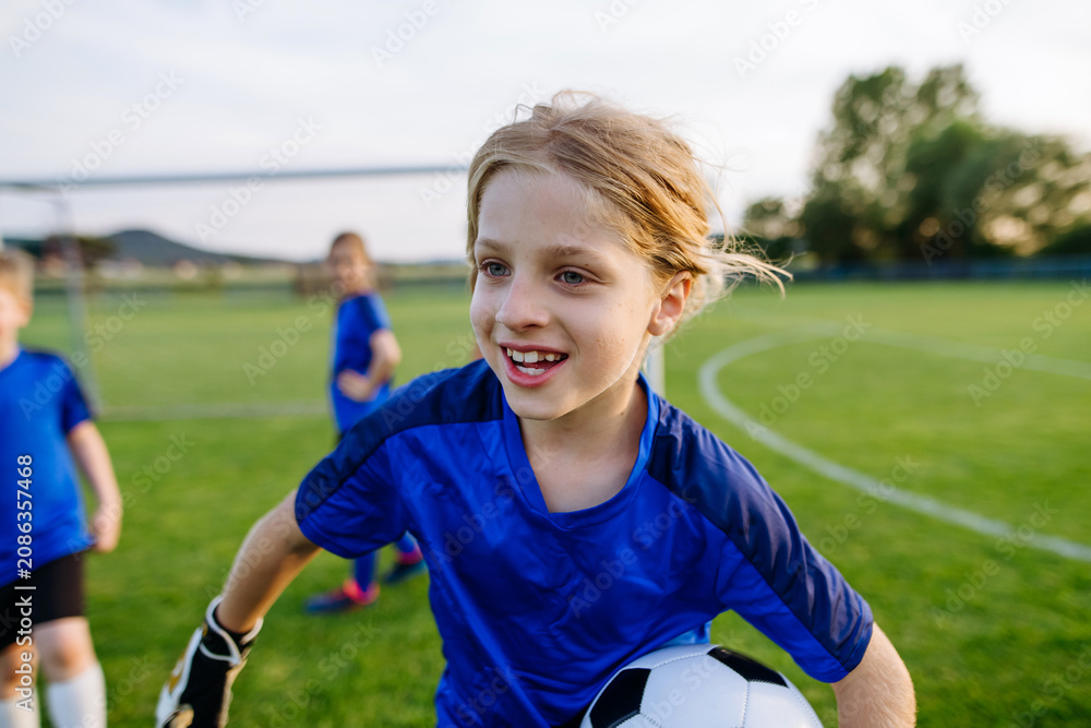 Fototapeta premium Young football players competing for ball during soccer match.