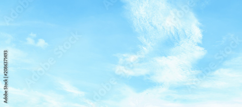 the sky is clear blue with fluffy white clouds, the sky is very bright, and the sun shines.