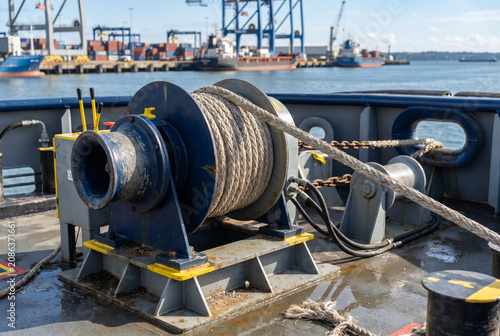 Tugboat capstan winch with rope on deck at harbor