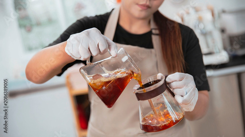 Canvastavla Professional barista pouring freshly brewed coffee into a glass server in a modern cafe, specialty coffee preparation concept