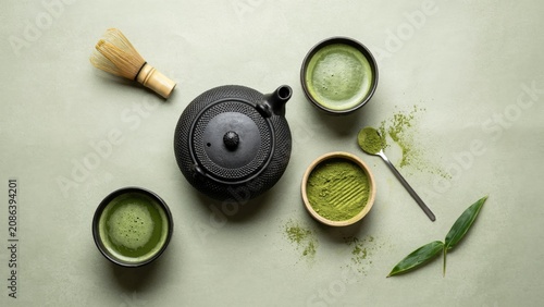 Matcha green tea set with whisk and powder on a light green background