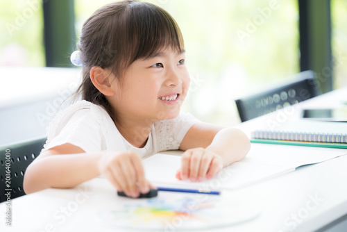 Photos A young girl, around kindergarten or elementary school age, concentrating on her