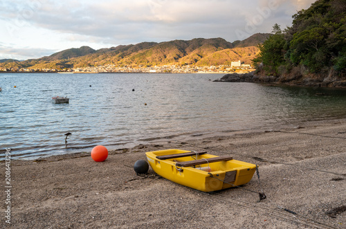 A small yellow boat resting on the shore of the Seto Inland Sea