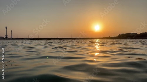 Sunset over the sea. Water surface with a golden light reflecting on gentle ocean waves. Beautiful summer sunset over the sea.