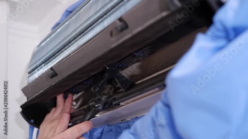 Close-up of a service technician cleaning the fan of a split air conditioning system