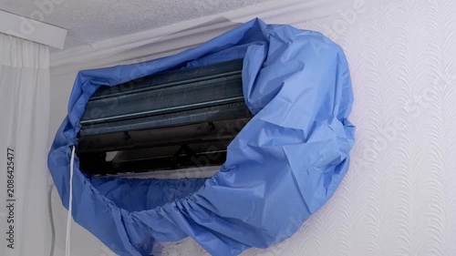 Protective blue cover on an indoor air conditioner unit during cleaning service and maintenance