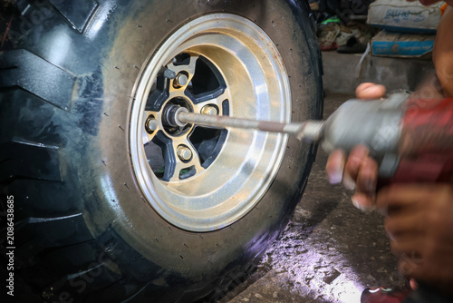 Valokuva Close up of person using power tool to tighten or loosen lug nuts on large tire