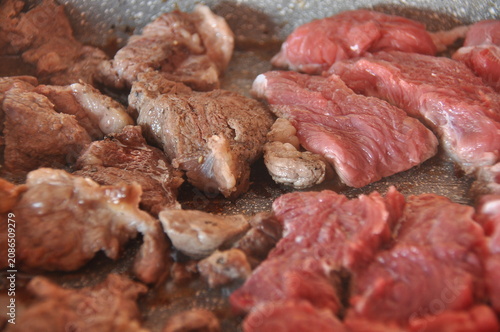 Beef being cooked on a skillet in a kitchen during a casual lunch preparation