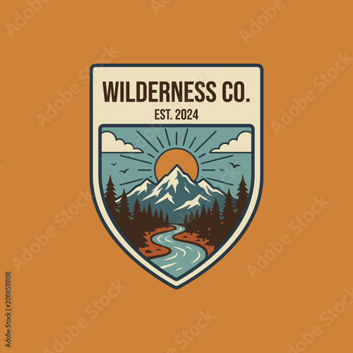 A retro-style wilderness badge featuring mountains, a river, and a sun, representing adventure and nature, evoking a sense of exploration and appreciation for the great outdoors.