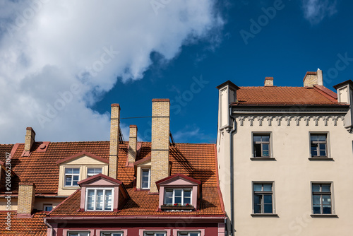 Historic European Buildings With Red Tile Roofs Under a Blue Sky