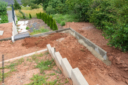 Construction site with concrete retaining wall. Backyard landscaping and ground leveling process