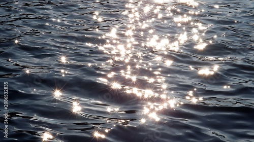 Sparkling sun glare creates starburst patterns on dark tranquil water