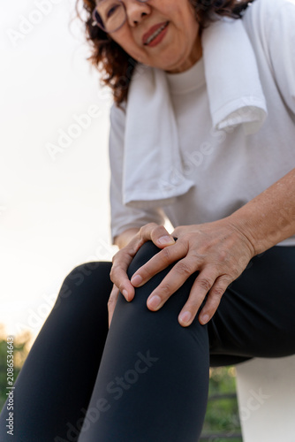 Foto Elderly woman hand massaging her leg suffering leg pain showing senior health problems with muscle pain and joint stiffness, insurance in retirement for wellbeing and quality of life