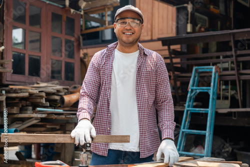 Foto Portrait carpenter man working on DIY woodworking project at home workshop