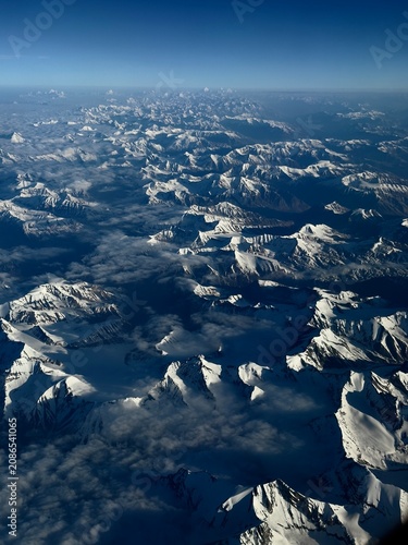 Breathtaking aerial view of snow-capped mountains above the clouds