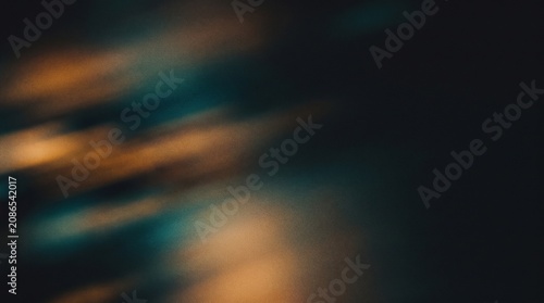 Abstract dark moody background with amber light leaks and grainy film texture